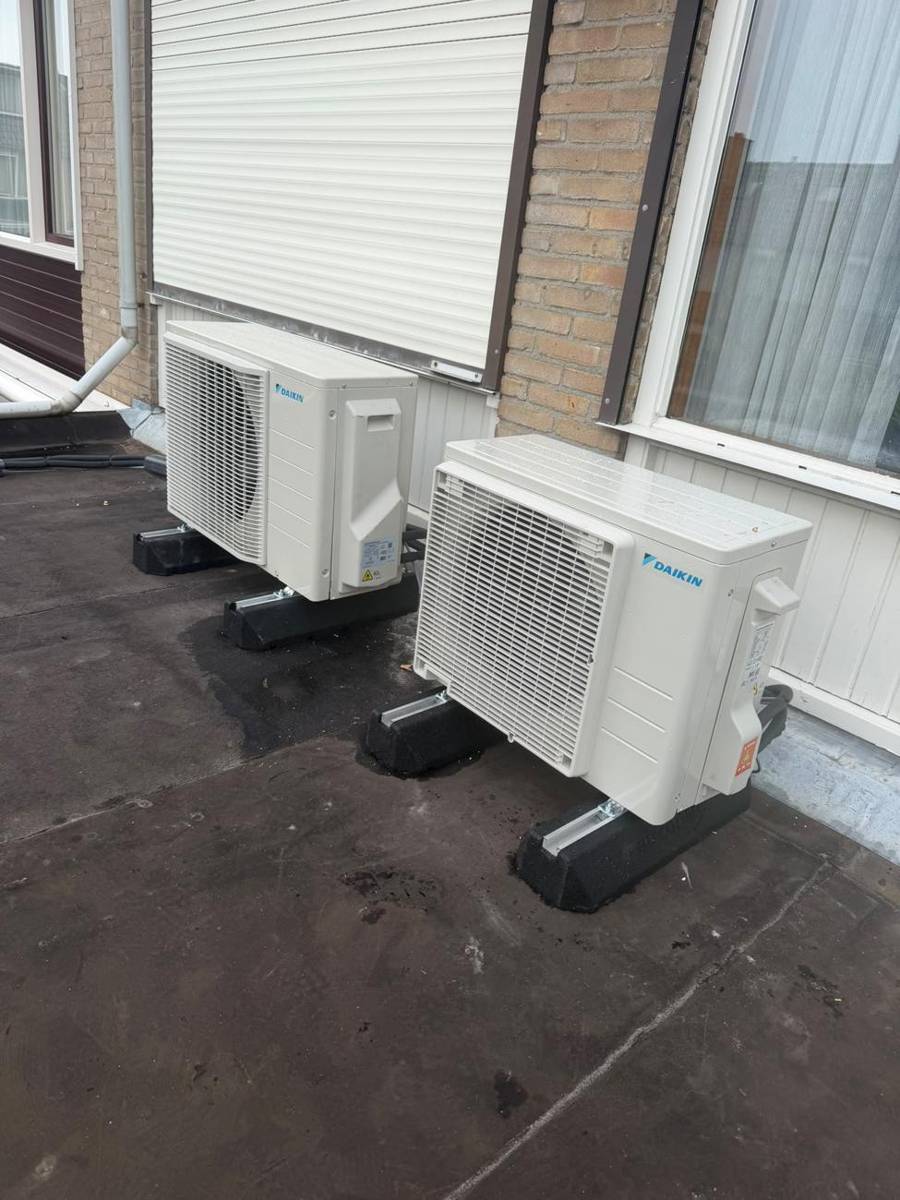 Twee Daikin buitendelen op dakvoeten op een plat dak